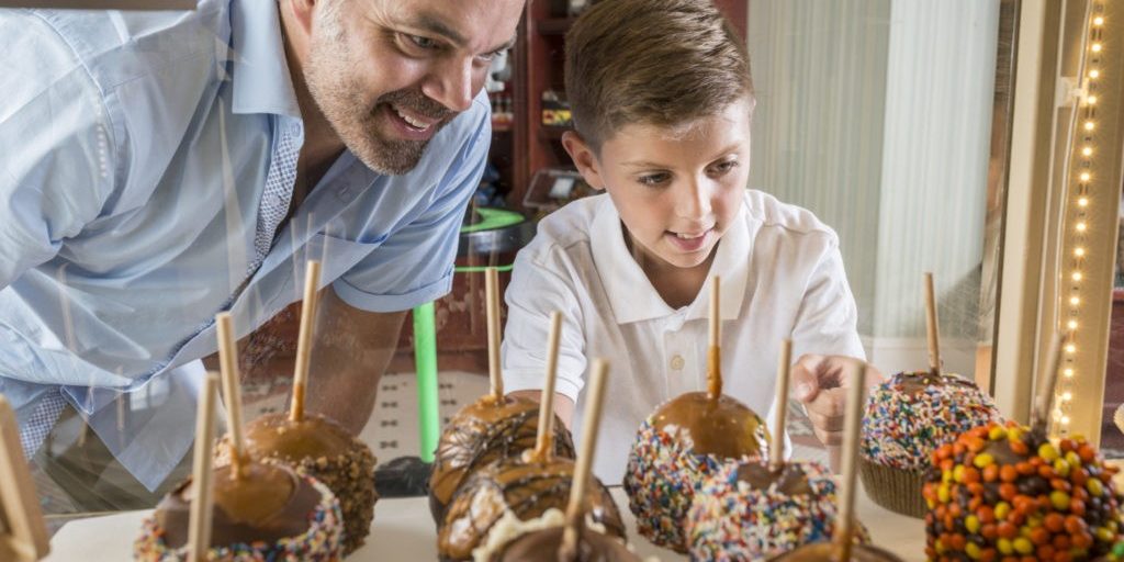 A picture of a father and son looking at the candy apples in Jenksinon's Sweet Shop.