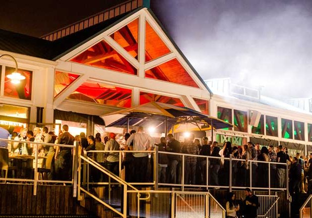 A view of people hanging outside on the back deck of Jenk's club, everyone talking and having fun.